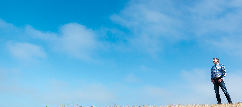 Jack in a field with a backdrop of clouds